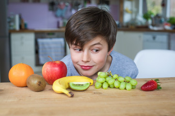 Obraz premium Junge isst vitaminreiches Obst und Früchte für eine gesunde Ernährung