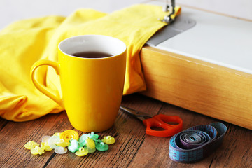 Yellow cup of tea and colorful buttons