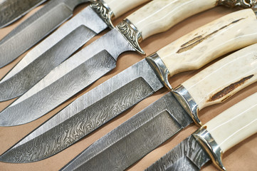 Forged hunting knives on beige
