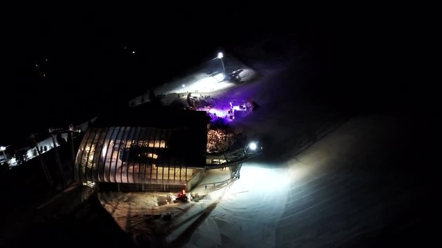Aerial view on funicular station which is located on mountain and night show is happening there at this time. Beautiful building at night. Solden, Austria, 4K footage