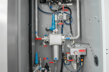closeup control valves and taps in a metal shield