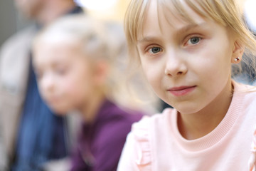 Portrait of a blond girl in a pink jumper