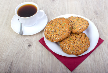 A cup of coffee and biscuits. On a wooden background.