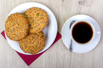 A cup of coffee and biscuits. On a wooden background.