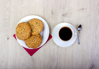 A cup of coffee and biscuits. On a wooden background.