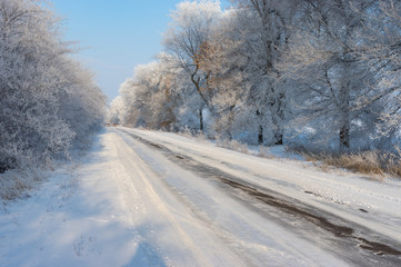 Winter landscape with slippery country road leading to Novo-Nikolaevka village in Dnepropetrovskaya oblast, Ukraine.