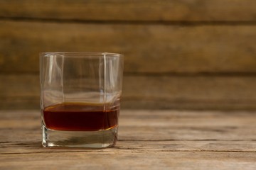 Glass of whisky on wooden table