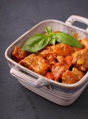 Ragout of meat with onions, carrots and tomatoes, decorated with basil,