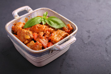 Ragout of meat with onions, carrots and tomatoes, decorated with basil,