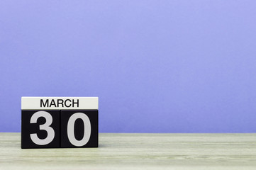 March 30th. Day 30 of month, calendar on table with purple background. Spring time, empty space for text