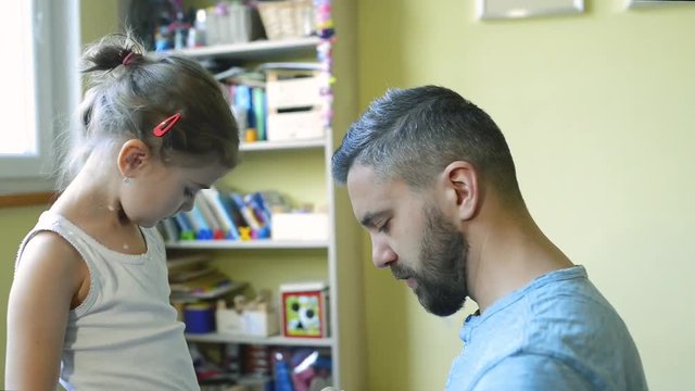 Little girl with chickenpox, father applying antiseptic cream to rash