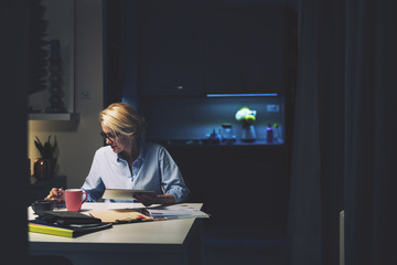 Businesswoman using technologies while sitting at desk in home office
