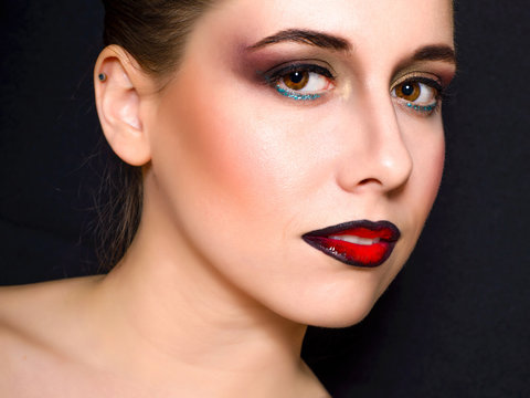 Blonde with professional make-up with dark red lips on a dark background