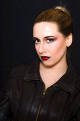 Blonde with professional make-up with dark red lips on a dark background