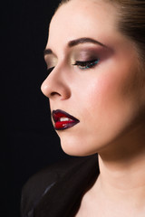 Blonde with professional make-up with dark red lips on a dark background