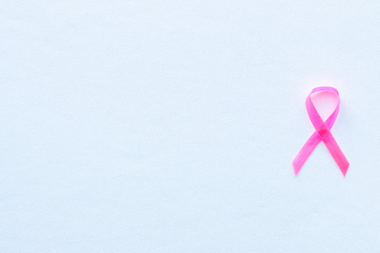 pink ribbon breast cancer symbol on white background and space for text