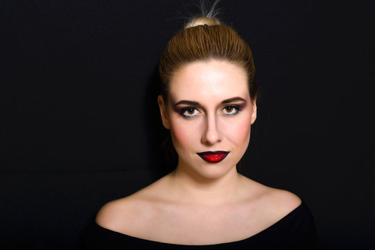 Blonde with professional make-up with dark red lips on a dark background