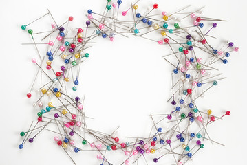 many colored sewing pins with empty space for text on white background