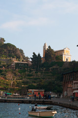 Italia, 16/03/2017: la baia di Portofino con vista della chiesa di San Giorgio, costruita nel 1154, che conserva le reliquie del santo patrono della citt&agrave; portate dai marinai veterani dalle Crociate