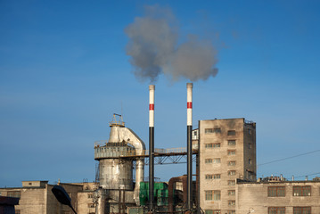 Old plant polluting atmosphere with two chimneys.