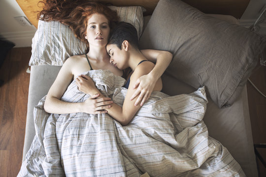 Overhead view of couple relaxing on bed at home