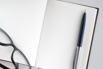 pen, glasses and notepad for writing text