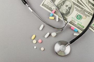 A lot of pills and money on the grey background