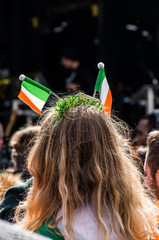 People celebrating St. Patrick day in Trafalgar Square while on stage performing Irish music groups