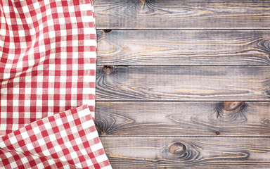 White old wooden table with red checkered tablecloth, top view with copy space