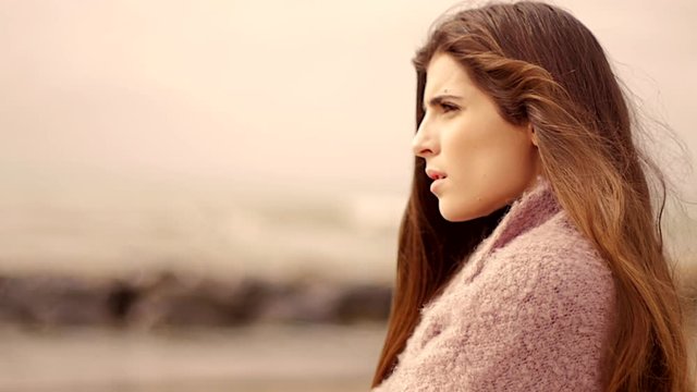 Woman thinking about love in front of the ocean slow motion profile