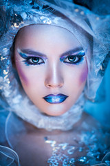 Winter beauty woman. Fashion portrait over blue snow Background.