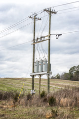 Three Electric Utility Transformers On Telephone Poles