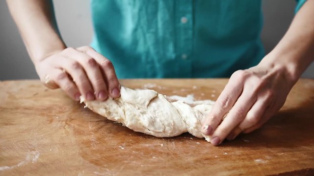 Close-up of young housewife preparing bread dough. 