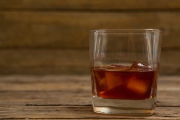 Glass of whisky with ice cube