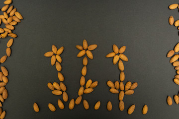 Almond nuts in the form of flowers on a black background.