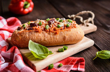 Baked baguette stuffed with mixture of minced pork, tomato sauce, beans, green bell pepper, onion,...