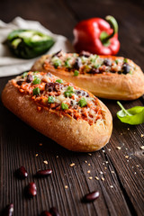 Baked baguette stuffed with mixture of minced pork, tomato sauce, beans, green bell pepper, onion, garlic and sprinkled with cheese