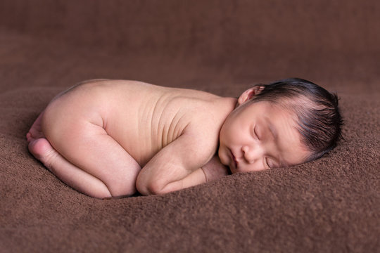 Beautiful newborn baby girl asleep on a soft blanket