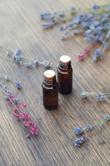 Essential oil and herbs on wooden background