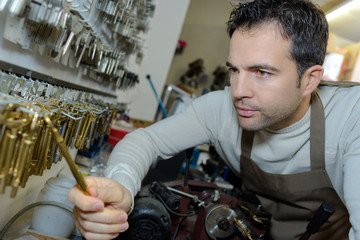 Key cutter selecting key from stock