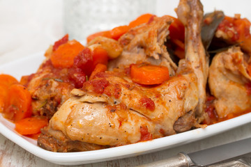 rabbit stew with carrot and tomato on white dish
