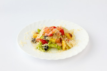 Салат с креветками. Креветки, помидор, маслины, листья салата посыпаны тертым твердым сыром