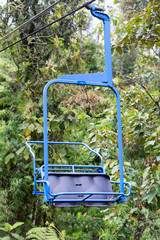 A closeup of a blue chair on the ski lift at the Recinto del Pensamiento nature reserve near Manizales, Colombia.