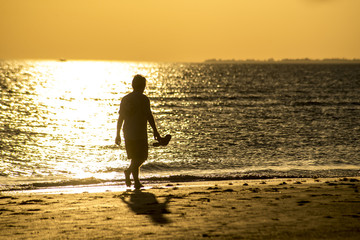 Fototapeta na wymiar Man's silhouette on the beach at sunset.