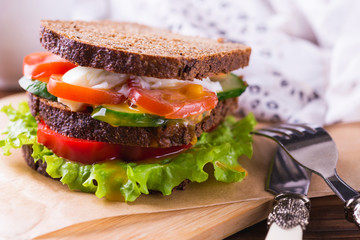Sandwich with cherry tomatoes, cucumber and lettuce and coffee