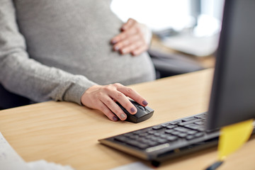 pregnant businesswoman with computer at office