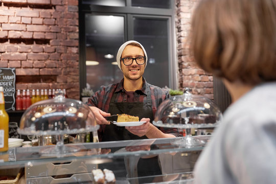 Man Or Barman With Cake Serving Customer At Cafe