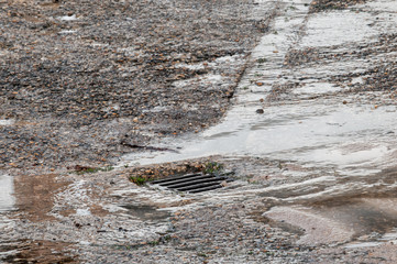 water damage to road from burst leaking water pipe