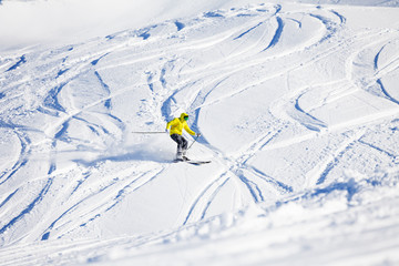 Sporty man skiing downhill in high mountains
