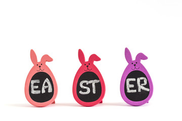 Written word Easter on three Bunny Eggs isolated on white. Greeting card concept, copy space
